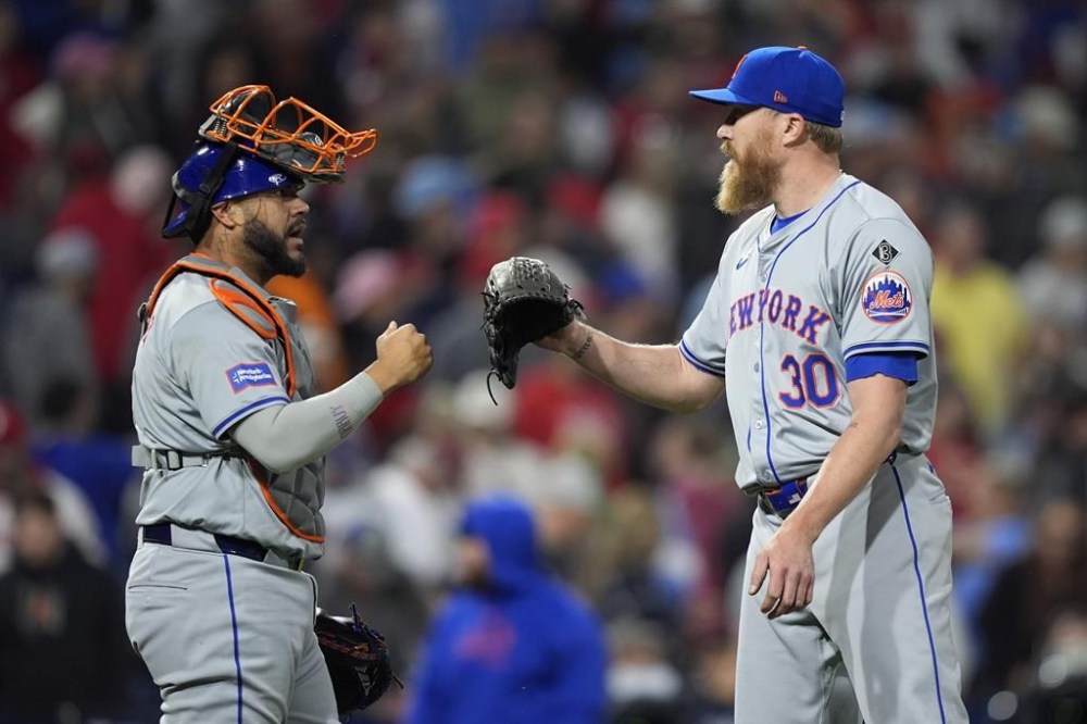 New York Mets' Omar Narvaez, left, and Jake Diekman celebrate after the Mets won an 11th inning baseball game against the Philadelphia Phillies, Thursday, May 16, 2024, in Philadelphia. (AP Photo/Matt Slocum)
