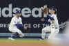 Los Angeles Dodgers center fielder James Outman, right, makes a sliding catch next to left fielder Chris Taylor on a fly ball by Miami Marlins' Josh Bell during the sixth inning of a baseball game Tuesday, May 7, 2024, in Los Angeles. (AP Photo/Marcio Jose Sanchez)