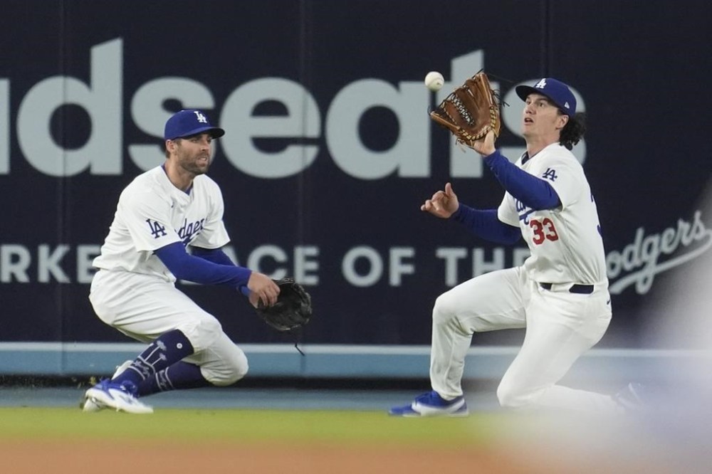 Los Angeles Dodgers center fielder James Outman, right, makes a sliding catch next to left fielder Chris Taylor on a fly ball by Miami Marlins' Josh Bell during the sixth inning of a baseball game Tuesday, May 7, 2024, in Los Angeles. (AP Photo/Marcio Jose Sanchez)