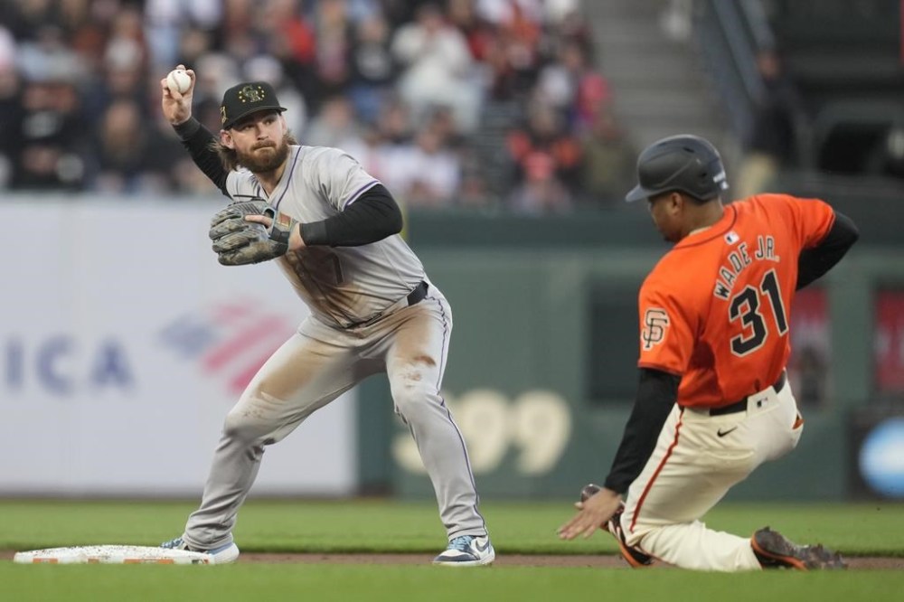 Colorado Rockies second baseman Brendan Rodgers throws to first base after forcing out San Francisco Giants' LaMonte Wade Jr. (31) at second base during the first inning of a baseball game in San Francisco, Friday, May 17, 2024. Thairo Estrada was safe at first. (AP Photo/Jeff Chiu)