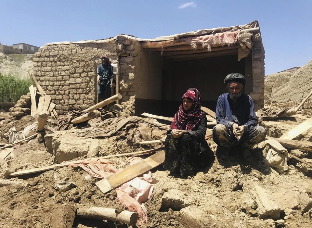 An Afghan couple sit near to their damaged home after heavy flooding in Ghor province in western Afghanistan Saturday, May 18, 2024. Flash floods from heavy seasonal rains in Ghor province in western Afghanistan killed dozens of people and dozens remain missing, a Taliban official said on Saturday, adding the death toll was based on preliminary reports and might rise. (AP Photo/Omid Haqjoo)