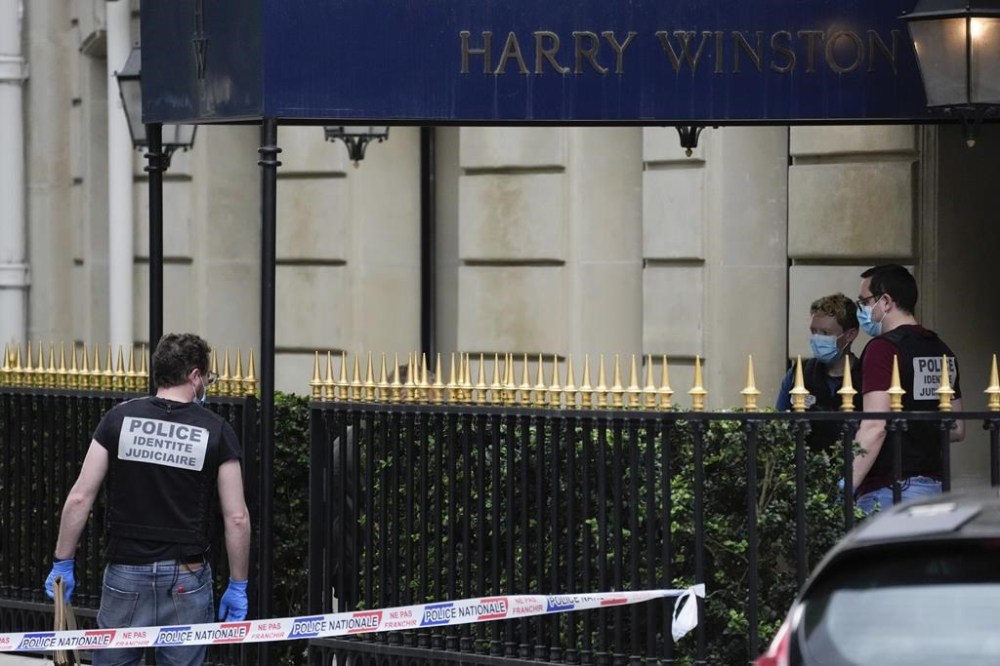 Police forensic officers inspect the entrance of the Harry Winston jewelry after a robbery in Paris, Saturday, May 18, 2024. French police investigators were hunting Saturday for armed robbers on motorbikes who hit a jewelry store on one of Paris' poshest streets, and media reports said the target was the exclusive Harry Winston boutique, self-described