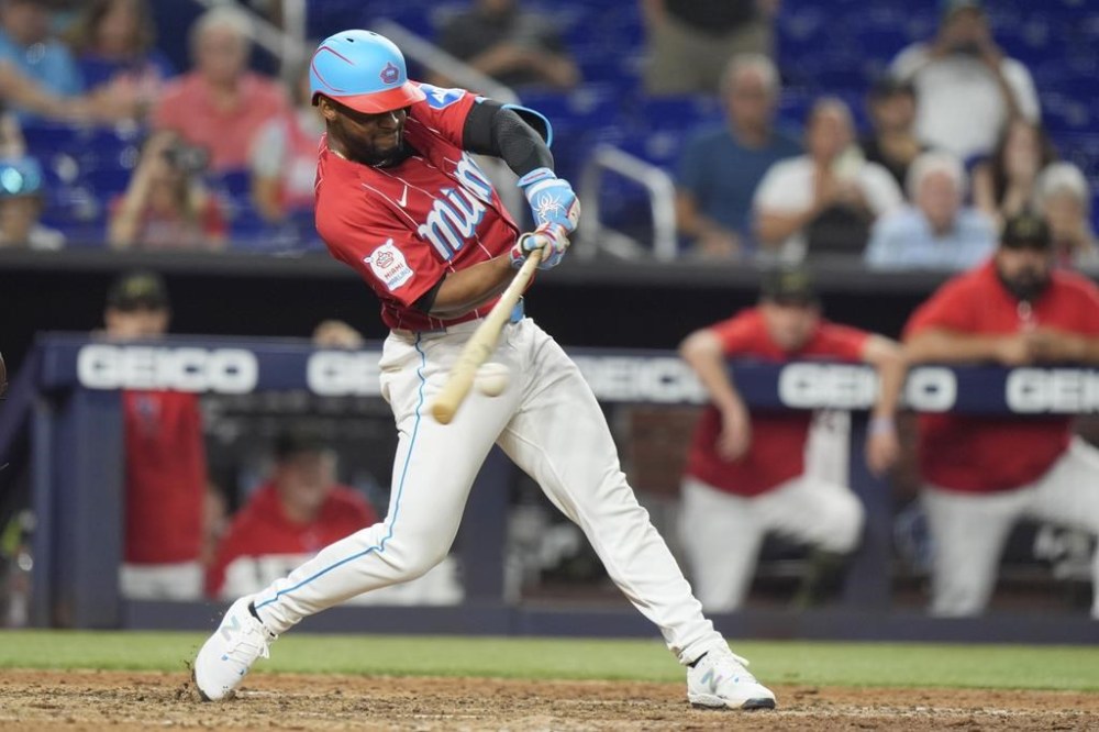 Miami Marlins' Otto Lopez hits a single to score Christian Bethancourt to beat the New York Mets 10-9, in 10 innings of a baseball game, Saturday, May 18, 2024, in Miami. (AP Photo/Wilfredo Lee)