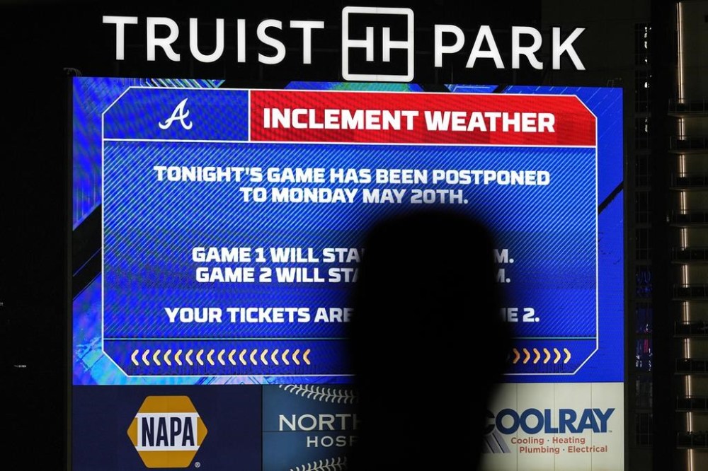 A fan moves in Truist Park after baseball game was postponed between the Atlanta Braves and the San Diego Padres do to rain, Saturday, May 18, 2024, in Atlanta. (AP Photo/Mike Stewart)