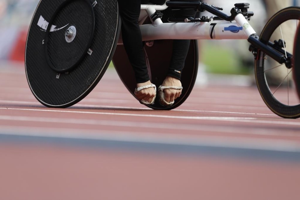 FILE - The padded hands of Diane Roy of Canada are seen as she waits to compete in the women' 800-meter T54 heat at the 2012 Paralympics games, on Sept. 4, 2012, in London. With an assist from Paul McCartney, the Paralympic Games starts its 100-day race Monday to the opening ceremony in Paris in August. (AP Photo/Alastair Grant)