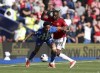 Brighton's Joao Pedro, left and Manchester United's Aaron Wan-Bissaka viefor the ball, during the English Premier League soccer match between Brighton & Hove Albion and Manchester United, at the Amex Stadium, in Brighton and Hove, England, Sunday, May 19, 2024. (Steven Paston/PA via AP)