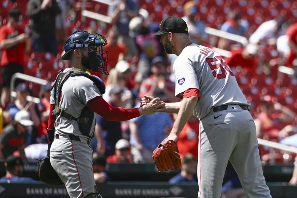 Boston Red Sox catcher Connor Wong, left, celebrates with teammate Chris Martin, right, after beating the St. Louis Cardinals after a baseball game, Sunday, May 19, 2024, in St. Louis. (AP Photo/Joe Puetz)