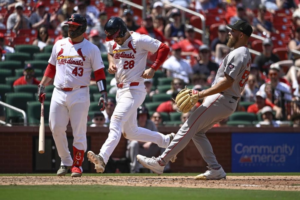 St. Louis Cardinals' Nolan Arenado (28) scores on a passed ball throw by Boston Red Sox relief pitcher Greg Weissert, right, as Cardinals' Pedro Pages, left, looks on in the seventh inning of a baseball game, Sunday, May 19, 2024, in St. Louis. (AP Photo/Joe Puetz)