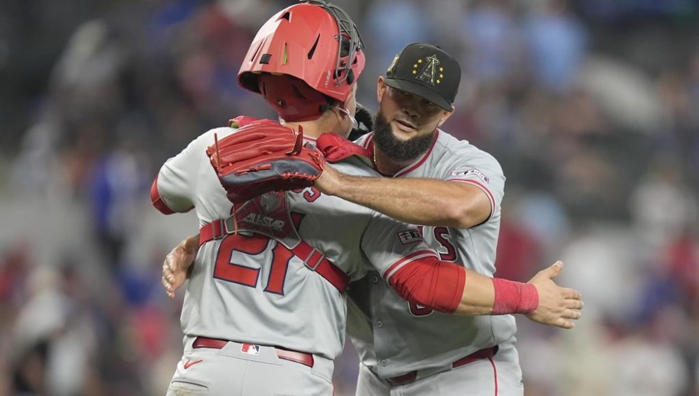 Los Angeles Angels closer Luis Garcia, right gets a hug from teammate catcher Matt Thaiss (21) after the final out ending the ninth inning of a baseball game against the Texas Rangers in Arlington, Texas, Sunday, May 19, 2024. (AP Photo/LM Otero)