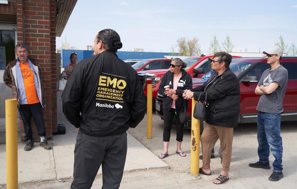 Manitoba Premier Wab Kinew speaks with evacuees from the Cranberry Portage area in The Pas, Man., as wildfires burn in northern Manitoba, Tuesday, May 14, 2024. THE CANADIAN PRESS/David Lipnowski