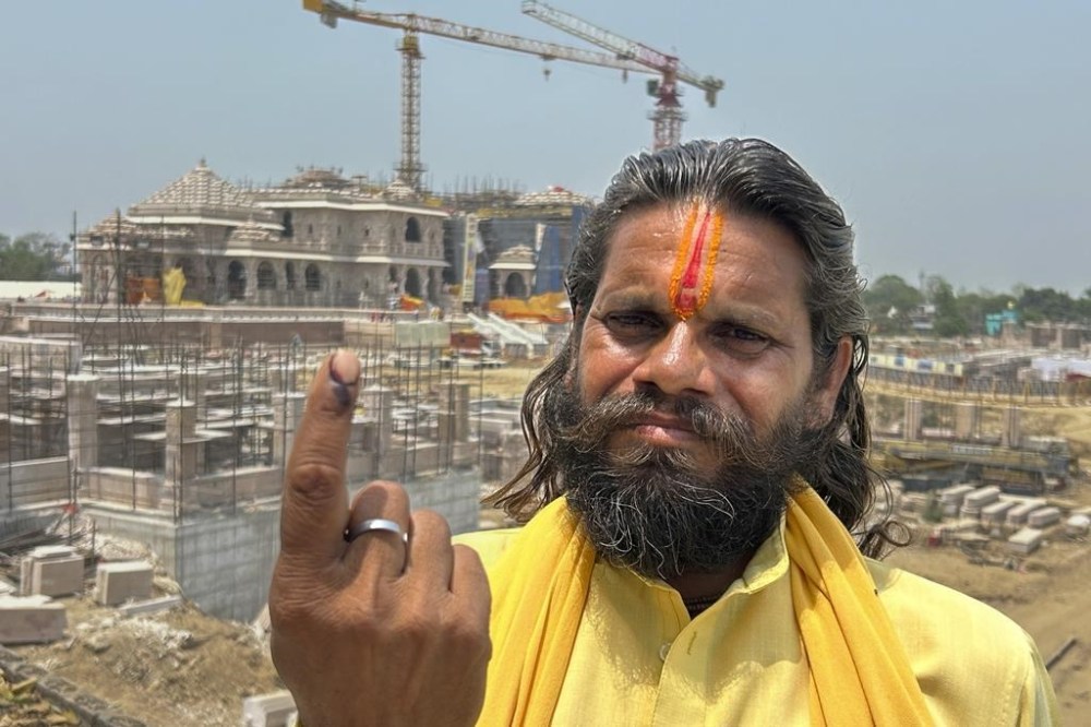 An Indian Hindu holy man who voted in the morning displays ink mark on his finger in front of the temple of Hindu god Ram during the fifth round of multi-phase national elections in Ayodhya, India, Monday, May 20, 2024. Indian Prime Minister Narendra Modi this year opened the controversial Hindu temple built on the grounds of a centuries-old mosque razed by Hindu mobs in 1992. (AP Photo/Rajesh Kumar Singh)