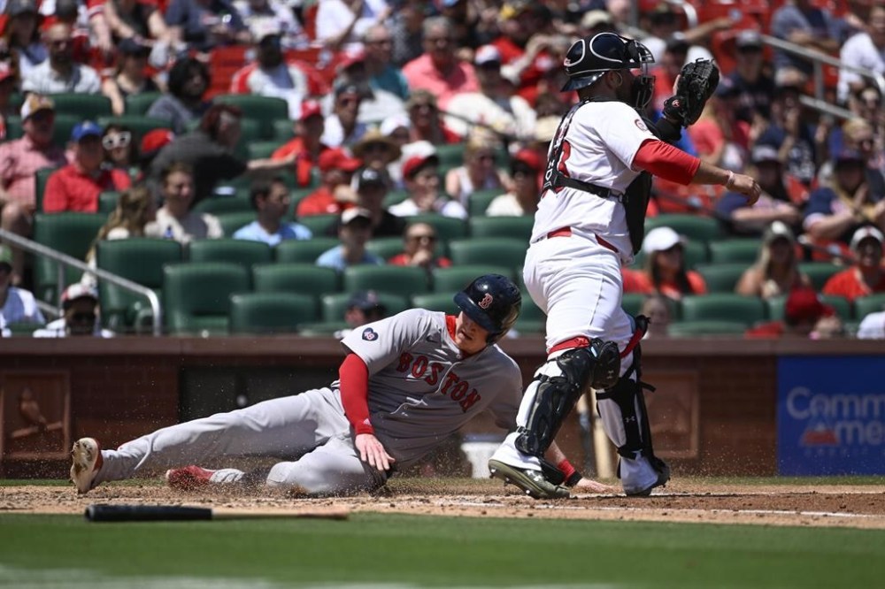 Boston Red Sox's Garrett Cooper, left, slides safely into home plate for a run ahead of the tag by St. Louis Cardinals catcher Pedro Pages, right, in the fourth inning of a baseball game Sunday, May 19, 2024, in St. Louis. (AP Photo/Joe Puetz)