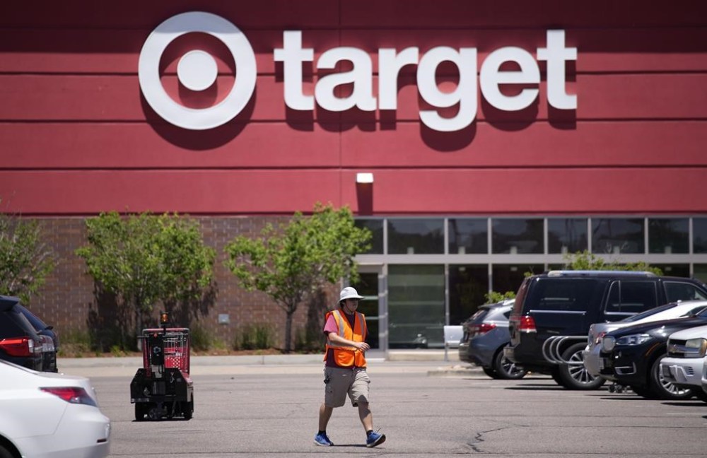 FILE - A worker collects shopping carts in the parking lot of a Target store June 9, 2021, in Highlands Ranch, Colo. Target says it's cutting prices on about 5,000 food, beverage and household essential items, becoming the latest company to shift its pricing strategy as consumers pay closer attention to how they spend their money amid inflation concerns.(AP Photo/David Zalubowski, File)
