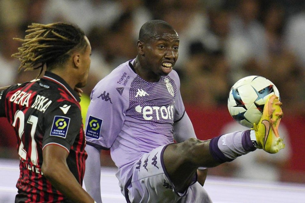 FILE - Monaco's Mohamed Camara, right, and Nice's Alexis Beka Beka challenge for the ball during the League One soccer match between Nice and Monaco at the Allianz Riviera stadium in Nice, Sunday, Sept. 4, 2022. French Sports Minister Amélie Oudéa-Castéra calls for sanctions against AS Monaco's Mohamed Camara after he covers the anti-homophobia logo on his jersey during the final Ligue 1 game Sunday. This incident marks the fourth consecutive year of controversy over the league's anti- discrimination efforts involving rainbow-colored symbols on jerseys. (AP Photo/Daniel Cole, File)