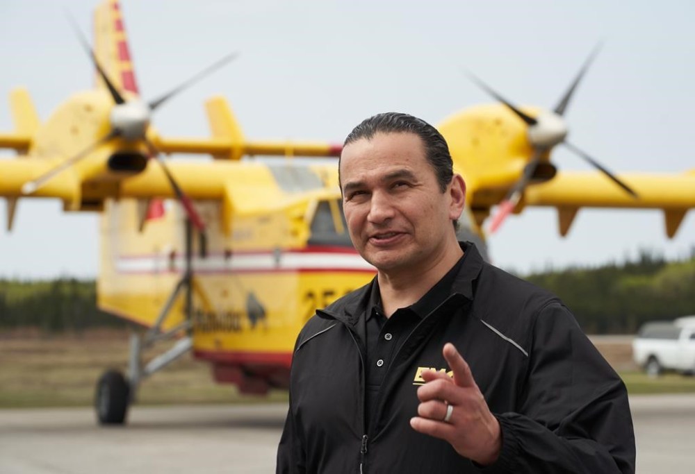 Manitoba Premier Wab Kinew has set the date for a byelection to fill a seat left vacant by former premier Heather Stefanson. Kinew speaks with firefighters at the Flin Flon airport, Tuesday, May 14, 2024. THE CANADIAN PRESS/David Lipnowski