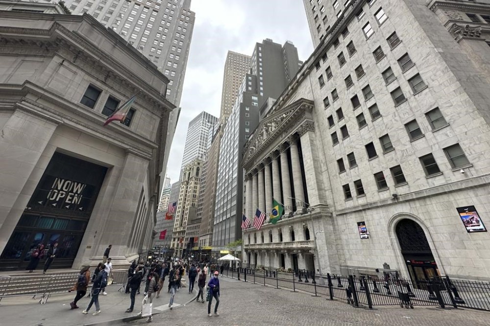 FILE - The New York Stock Exchange, right, is shown on May 16, 2024, in New York. Global shares have retreated Tuesday, May 21, 2024, even after most U.S. stock indexes finished higher, especially technology issues like Nvidia. (AP Photo/Peter Morgan, File)