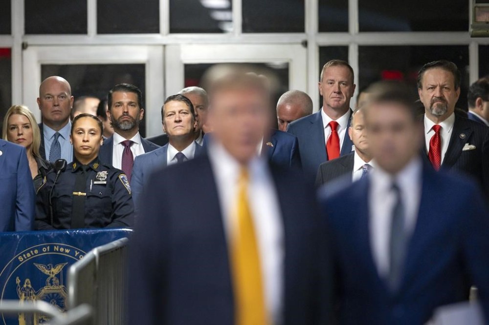 Supporters including former Acting United States Attorney General Matthew Whitaker, second from left, Donald Trump Jr., third form left, U.S. Sen Eric Schmitt, R-Mo., third from right, and radio host Sebastian Gorka, right, listen as former President Donald Trump speaks outside the courtroom at Manhattan Criminal Court, Tuesday, May 21, 2024, in New York. (Justin Lane/Pool Photo via AP)