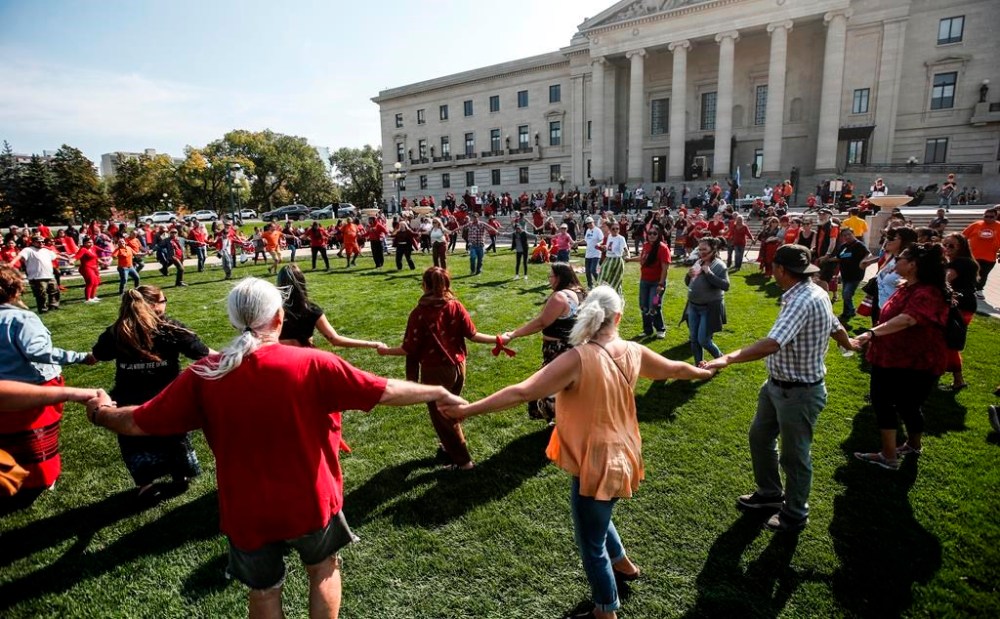 Supporters and family members round dance as they gather at a rally to search a landfill for three missing women at the Manitoba legislature in Winnipeg on Monday, Sept. 18, 2023. THE CANADIAN PRESS/John Woods