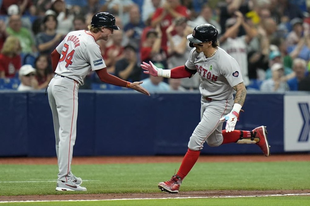 Boston Red Sox's Jarren Duran celebrates his solo home run off Tampa Bay Rays starting pitcher Zack Littell with third base coach Kyle Hudson (84) during the sixth inning of a baseball game Tuesday, May 21, 2024, in St. Petersburg, Fla. (AP Photo/Chris O'Meara)