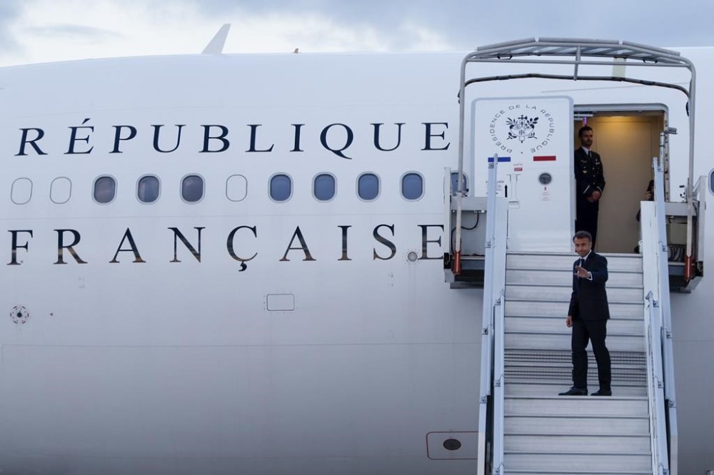 France's President Emmanuel Macron waves as he boards his Presidential plane to travel to the Pacific archipelago of New Caledonia, at the Orly airport, Paris Tuesday, May 21, 2024. (Ludovic Marin/Pool Photo via AP)