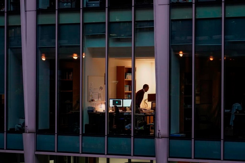 A study shows employers are rethinking their approach to fostering social connections among workers as remote and hybrid models continue. A worker is shown in an office in the financial district of London, Monday, Dec. 13, 2021. THE CANADIAN PRESS/AP/Alberto Pezzali