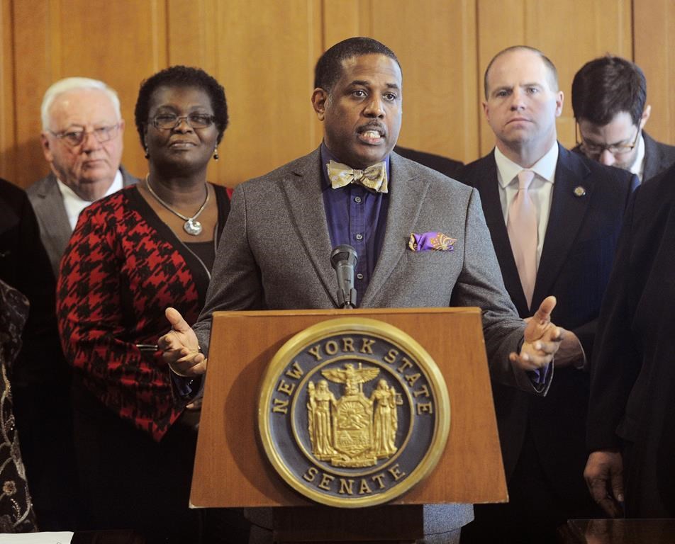 FILE - New York Sen. Kevin Parker, D-Brooklyn, stands at the podium, flanked by Senate members, Feb. 6, 2017, during a news conference at the Capitol in Albany, N.Y. Parker won’t face charges after he was accused of shoving an advocate twice in the state capitol building last week. Disability rights advocate Michael Carey told The Associated Press that he spoke with Parker on Friday, May 17, 2024, and that they “resolved things in a peaceable way.”(AP Photo/Hans Pennink, File)