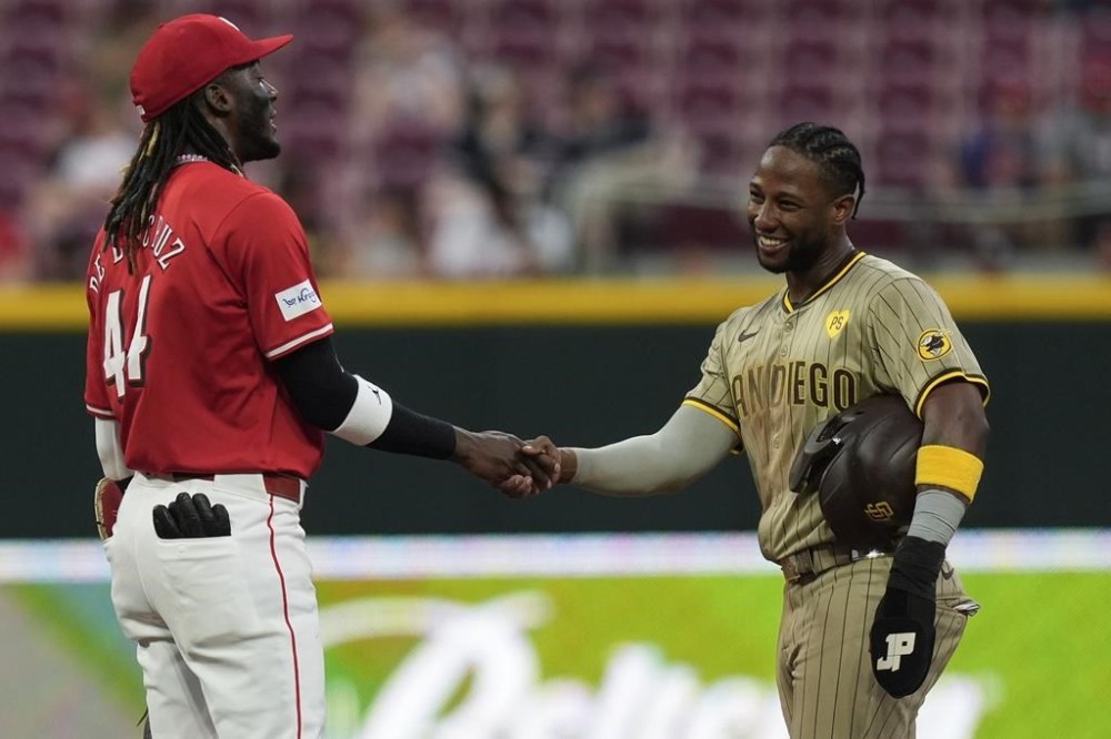 San Diego Padres' Jurickson Profar, right, and Cincinnati Reds shortstop Elly De La Cruz shake hands at second base during a pitching change in the fifth inning of a baseball game Wednesday, May 22, 2024, in Cincinnati. (AP Photo/Carolyn Kaster)