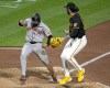 San Francisco Giants' LaMonte Wade Jr., left, scores past Pittsburgh Pirates relief pitcher Colin Holderman on a ground out by Jorge Soler during the eighth inning of a baseball game in Pittsburgh, Wednesday, May 22, 2024. (AP Photo/Gene J. Puskar)