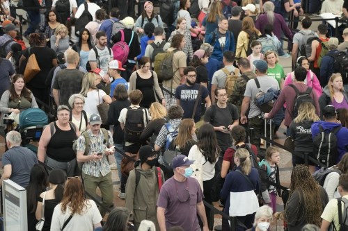 FILE - Travelers move through a security checkpoint in Denver International Airport ahead of the Memorial Day holiday on May 26, 2023, in Denver. A record number of Americans are expected to hit the pavement and the air over the 2024 Memorial Day weekend. (AP Photo/David Zalubowski, File)