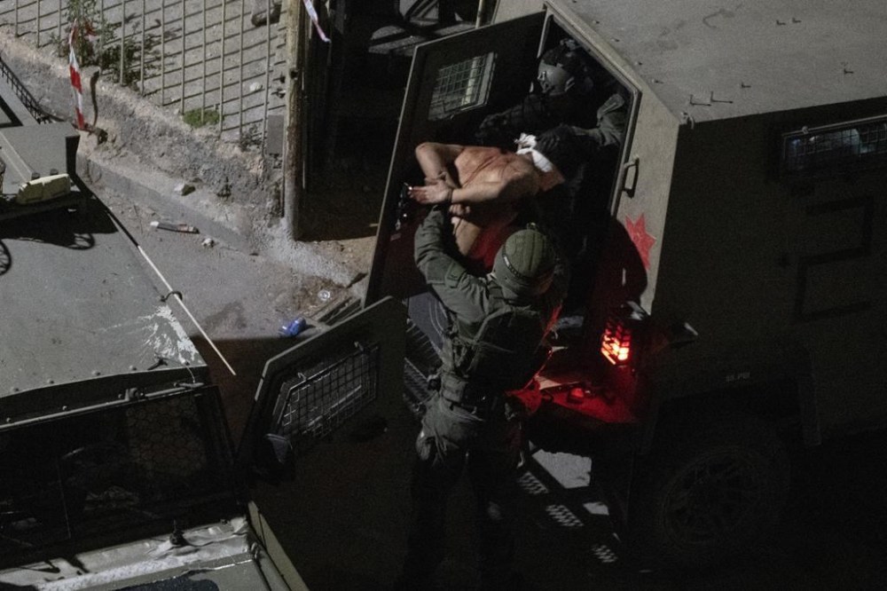 After being blindfolded, a Palestinian man is detained by Israeli forces during a raid in the West Bank city of Jenin, Thursday, May 23, 2024. (AP Photo/Leo Correa)