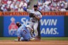 Texas Rangers second baseman Marcus Semien, right, throws to first after forcing out Philadelphia Phillies' Bryce Harper at second on a double play hit into by Alec Bohm during the fourth inning of a baseball game, Thursday, May 23, 2024, in Philadelphia. (AP Photo/Matt Slocum)