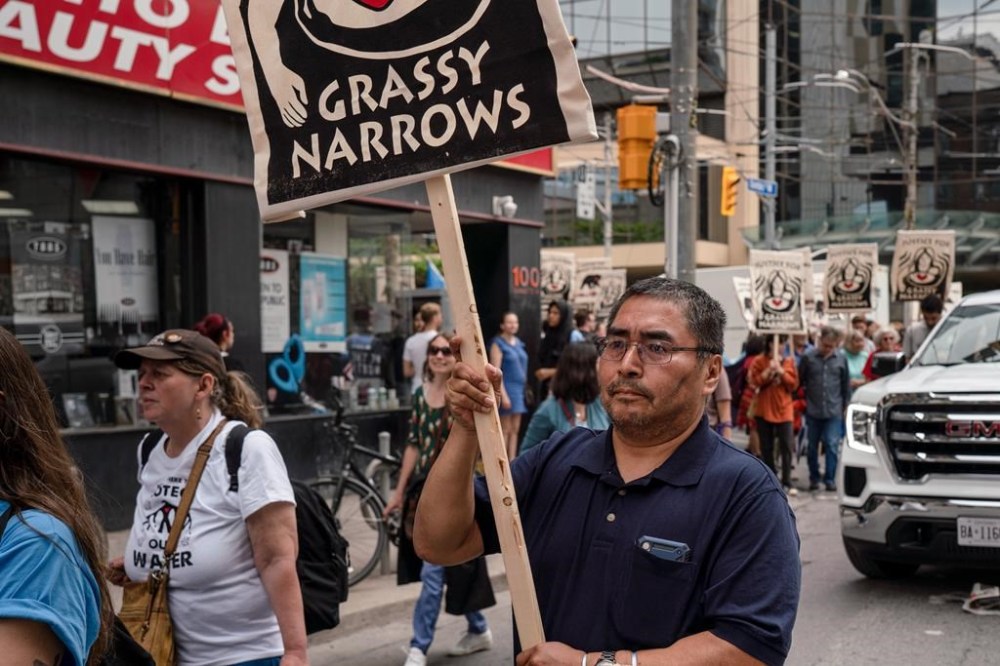 Industrial discharge from a paper mill in northern Ontario is exacerbating mercury contamination in a river system near a First Nation that has been plagued with mercury poisoning for decades, a new study suggests. Grassy Narrows Chief Rudy Turtle holds a sign as he marches with supporters through downtown Toronto in a 2019 handout photo. THE CANADIAN PRESS/HO-Allan Lissner, *MANDATORY CREDIT*