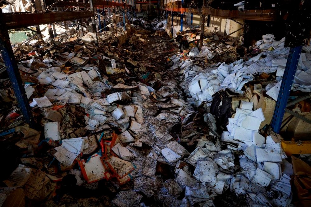 Burnt books are seen in a damaged workshop of Ukraine's largest printing house ruined in Thursday deadly Russian missile attack that killed seven civilians in Kharkiv, Ukraine, Friday, May 24, 2024. (Ukrainian Presidential Press Office via AP)