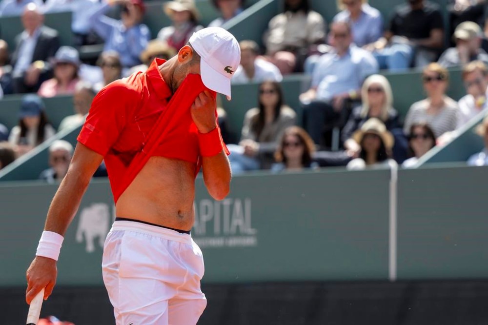 Novak Djokovic, of Serbia, wipe your eyes as he plays Tomas Machac, of the Czech Republic, during their semi-final match, at the ATP 250 Geneva Open tennis tournament in Geneva, Switzerland, Friday, May 24, 2024. (Martial Trezzini/Keystone via AP)