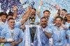 Manchester City's Kyle Walker, center, celebrates with the Premier League trophy with Manchester City's Phil Foden, and Manchester City's Jack Grealish after the English Premier League soccer match between Manchester City and West Ham United at the Etihad Stadium in Manchester, England, Sunday, May 19, 2024. Manchester City clinched the English Premier League on Sunday after beating West Ham in their last match of the season. (AP Photo/Dave Thompson)