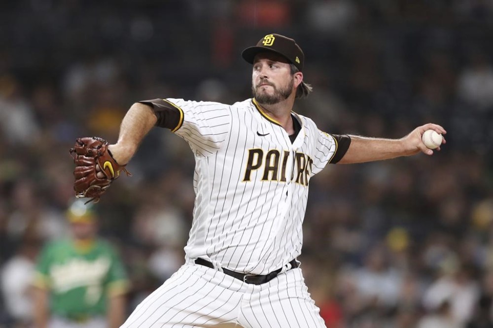 FILE - San Diego Padres relief pitcher Drew Pomeranz winds up during a baseball game against the Oakland Athletics, July 27, 2021, in San Diego. Pomeranz is back in the major leagues for the first time in three years, agreeing a one-year contract with the San Francisco Giants after opting out of a minor league deal with the Los Angeles Dodgers. (AP Photo/Derrick Tuskan, File)