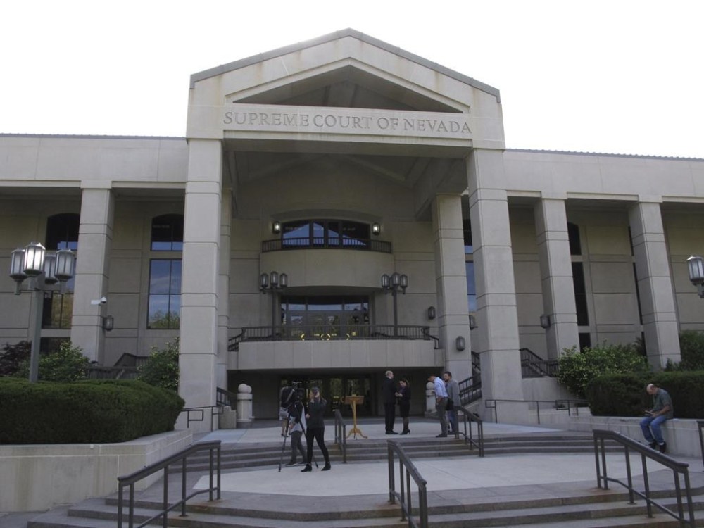 FILE - People gather outside the Nevada Supreme Court in Carson City, May 8, 2018. An initiative that would amend the Nevada Constitution to require that voters show photo identification at the polls can appear on the 2024 ballot as long as organizers collect enough signatures, the state Supreme Court ruled Friday, May 24, 2024. (AP Photo/By Scott Sonner, File)