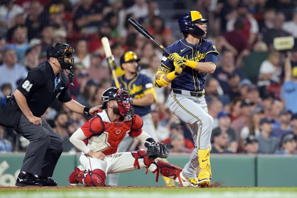 Milwaukee Brewers' Christian Yelich follows watches his RBI double in front of Boston Red Sox catcher Connor Wong during the fifth inning of a baseball game, Friday, May 24, 2024, in Boston. (AP Photo/Michael Dwyer)