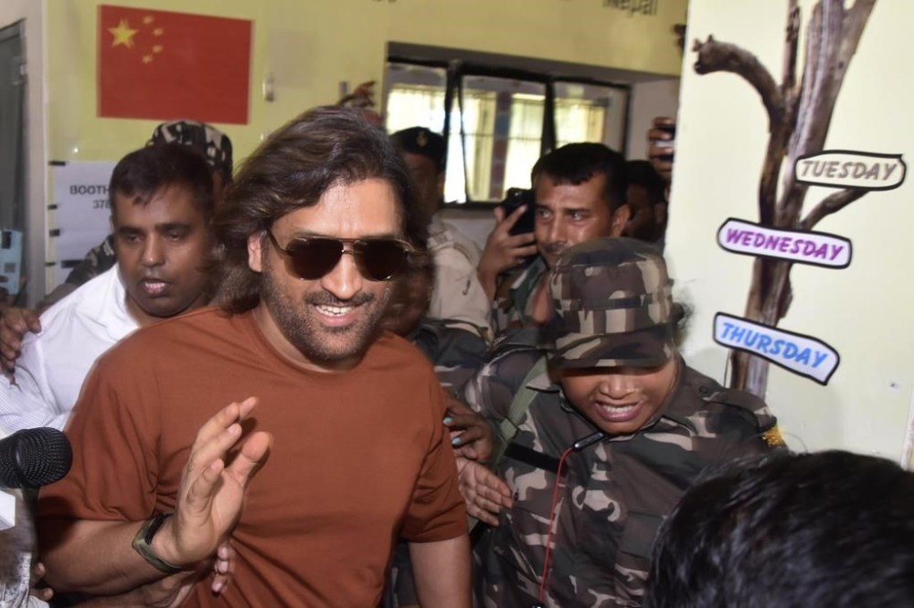 Indian cricketer MS Dhoni greets fans as he leaves after casting his vote at a polling station situated in a school building in Ranchi, Saturday, May 25, 2024. (AP Photo/Rajesh Kumar)