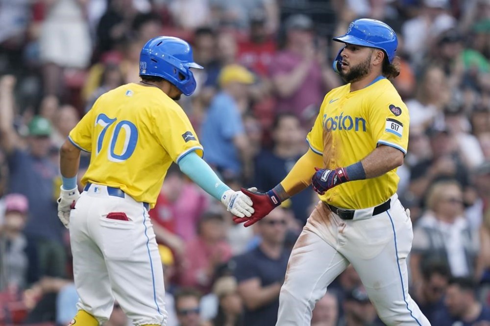 Boston Red Sox's Wilyer Abreu celebrates with David Hamilton (70) after scoring on a single by Ceddanne Rafaela against the Milwaukee Brewers during the seventh inning of a baseball game Saturday, May 25, 2024, in Boston. (AP Photo/Michael Dwyer)