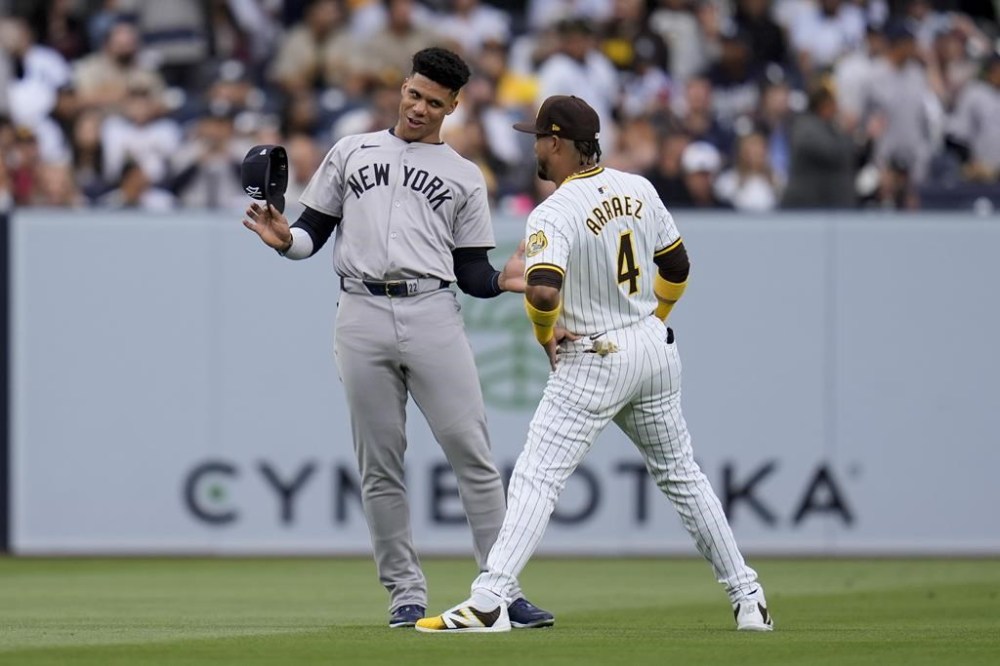 New York Yankees right fielder Juan Soto, left, jokes with San Diego Padres first baseman Luis Arraez before a baseball game, Saturday, May 25, 2024, in San Diego. (AP Photo/Gregory Bull)