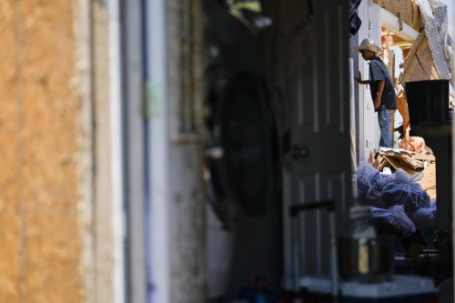 Larry Landeros, 9, who rode out a deadly tornado with his parents in their pick-up parked in their garage, looks through debris of his home, Sunday, May 26, 2024, in Valley View, Texas. Powerful storms left a wide trail of destruction Sunday across Texas, Oklahoma and Arkansas after obliterating homes and destroying a truck stop where drivers took shelter during the latest deadly weather to strike the central U.S. (AP Photo/Julio Cortez)
