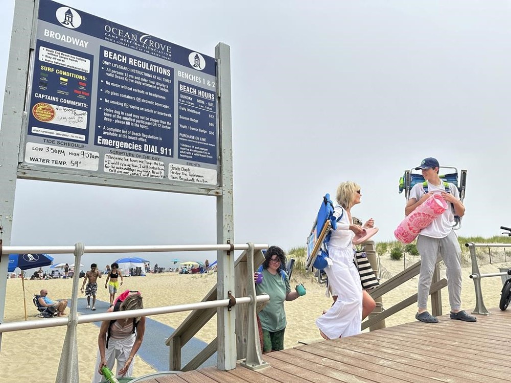 Beachgoers walked onto the boardwalk at Ocean Grove, N.J., on Sunday, May 26, 2024. Beachgoers were out on the sand of one New Jersey shore community on a Sunday morning before Memorial day for the first time in generations amid a battle over a Christian religious group’s Sunday morning beach closures. (AP Photo/Tassanee Vejpongsa)