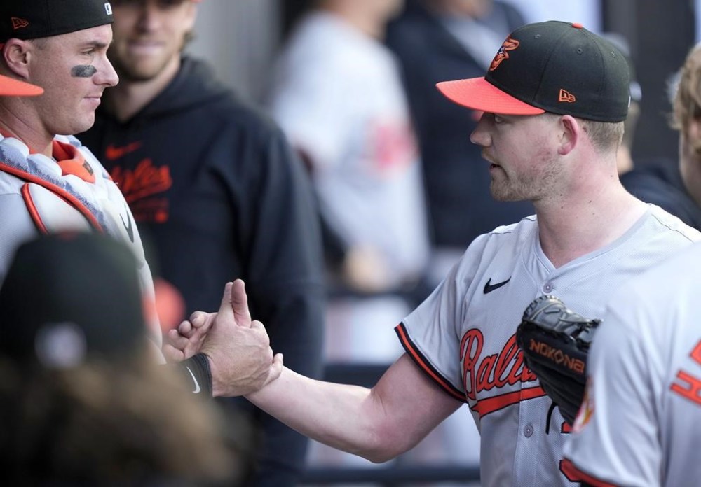 Baltimore Orioles catcher James McCann, left, shakes hands with starter pitcher Kyle Bradish, right, in the dugout after Bradish pitched seven innings of no-hit baseball in a game against the Chicago White Sox, Sunday, May 26, 2024, in Chicago. (AP Photo/Charles Rex Arbogast)