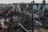 Palestinians look at the destruction after an Israeli strike where displaced people were staying in Rafah, Gaza Strip, Monday, May 27, 2024. Palestinian health workers said Israeli airstrikes killed at least 35 people in the area. Israel's army confirmed Sunday's strike and said it hit a Hamas installation and killed two senior Hamas militants. (AP Photo/Jehad Alshrafi)