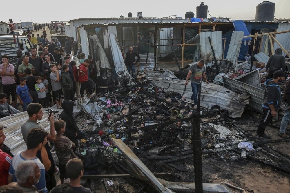 Palestinians look at the destruction after an Israeli strike where displaced people were staying in Rafah, Gaza Strip, Monday, May 27, 2024. Palestinian health workers said Israeli airstrikes killed at least 35 people in the area. Israel's army confirmed Sunday's strike and said it hit a Hamas installation and killed two senior Hamas militants. (AP Photo/Jehad Alshrafi)