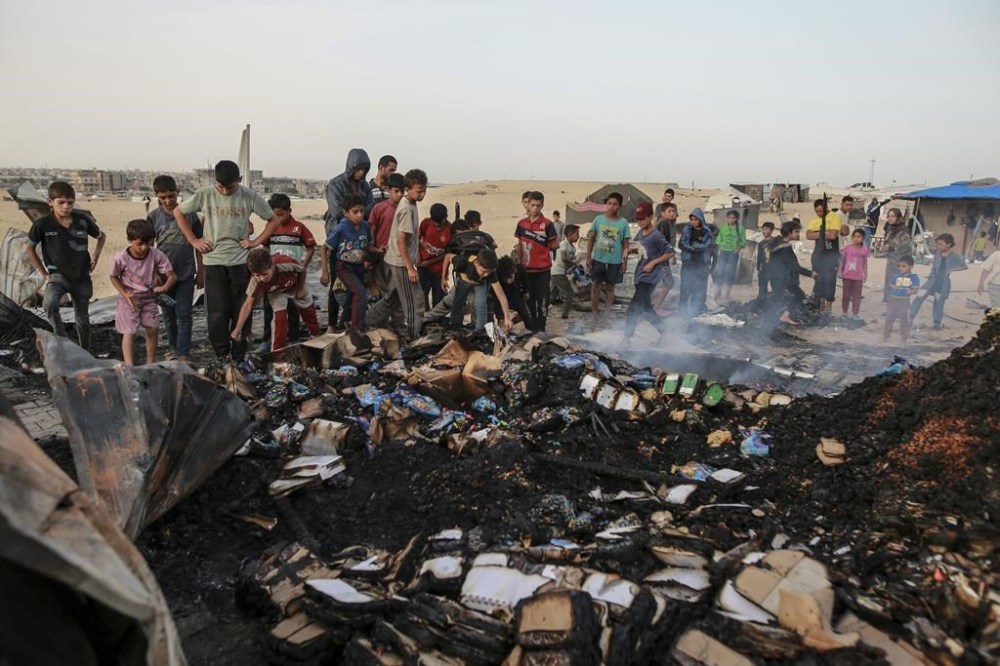 Palestinians look at the destruction after an Israeli strike where displaced people were staying in Rafah, Gaza Strip, Monday, May 27, 2024. Palestinian health workers said Israeli airstrikes killed at least 35 people in the area. Israel's army confirmed Sunday's strike and said it hit a Hamas installation and killed two senior Hamas militants. (AP Photo/Jehad Alshrafi)
