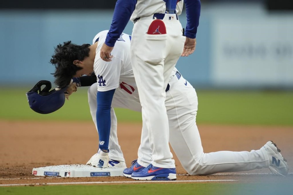 Los Angeles Dodgers designated hitter Shohei Ohtani (17) reacts after returning to first base during the first inning of a baseball game against the Cincinnati Reds in Los Angeles, Thursday, May 16, 2024. (AP Photo/Ashley Landis)