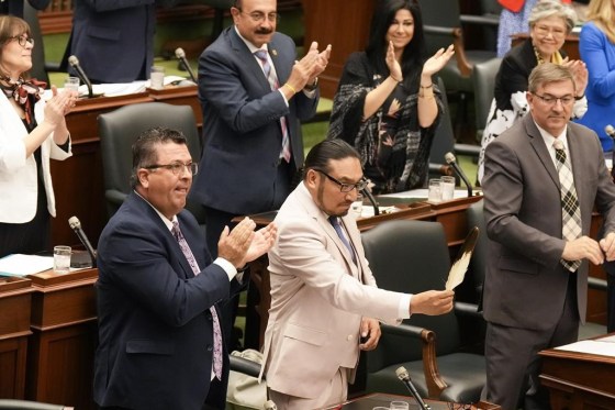 NDP MPP Sol Mamakwa brandishes an eagle feather towards the government benches as he stands in the Ontario Legislature on Tuesday. (Chris Young / The Canadian Press)