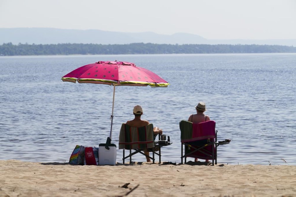 People take to the waters and shores of the Ottawa River in the Ottawa suburb of Constance Bay on Tuesday, July 6, 2023. The Weather Network is predicting more sunshine and warmer temperatures for the summer. THE CANADIAN PRESS/Sean Kilpatrick
